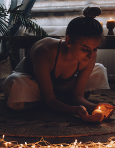 Image of a person practicing self love rituals with a candle.
